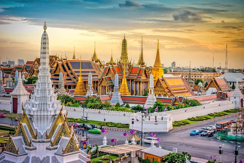 Tourists standing before the golden spires of the Grand Palace with ornate Thai architecture on a guided Bangkok Thailand tours temple circuit