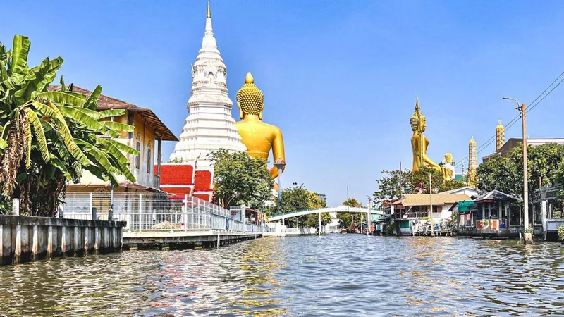 Private longtail boat speeding through narrow Bangkok canal past traditional wooden stilt houses on a private canal boat tour, Bangkok Thailand
