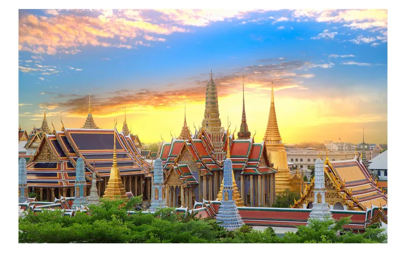 Tour group walking through the Grand Palace compound past gilded pagodas on a classic Bangkok Thailand tours temple itinerary