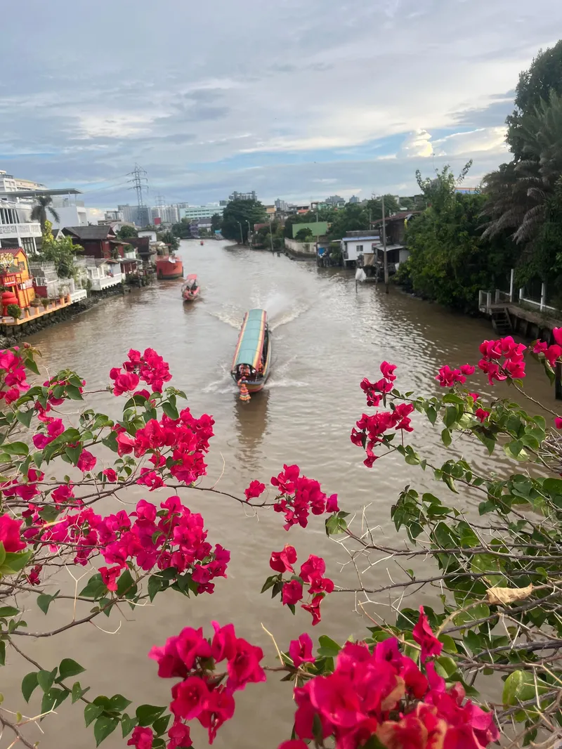 Tourists transitioning from a tuk tuk to a longtail boat on a Bangkok canal during a Bangkok Thailand tours tuk tuk and boat combo adventure